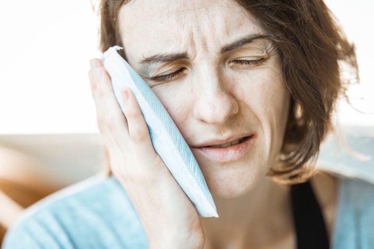 Woman in Blue Shirt Having Toothache