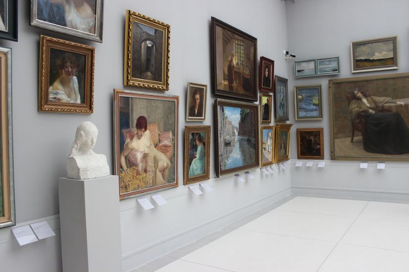 gallery, several paintings hanging, white wall