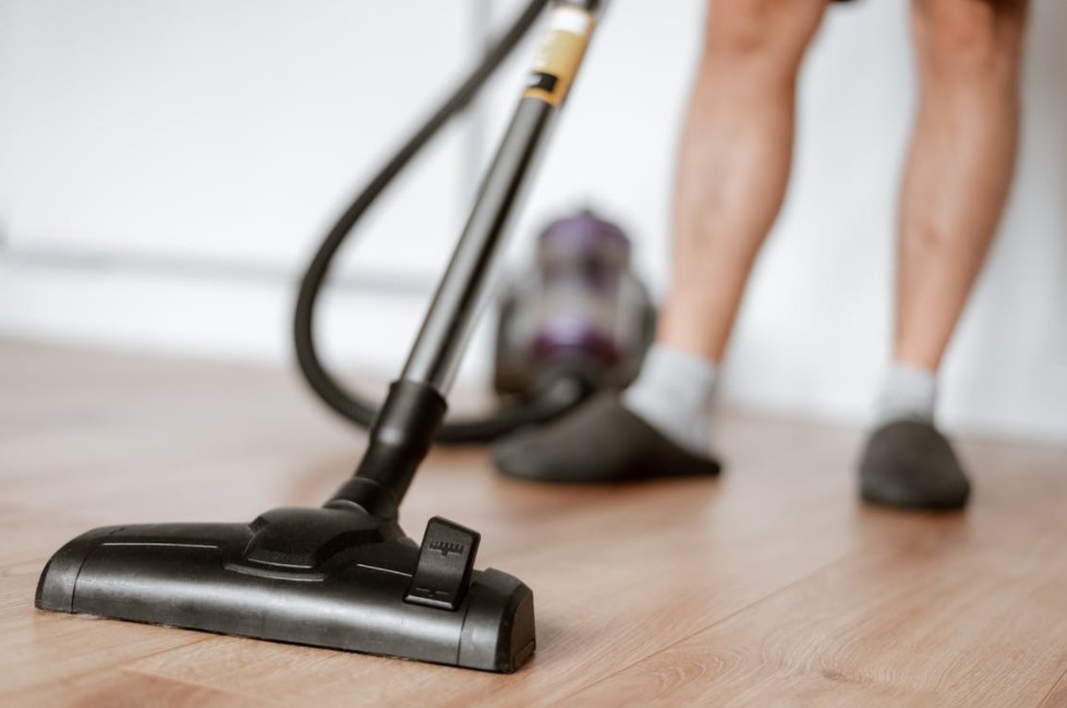 man-cleaning-floor-with-vacuum-cleaner