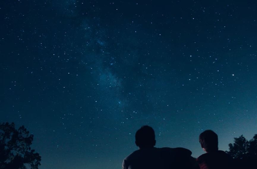 Two people observing the night sky